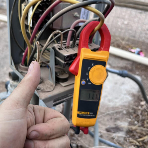 Water well electrical volt meter testing with thumbs up.